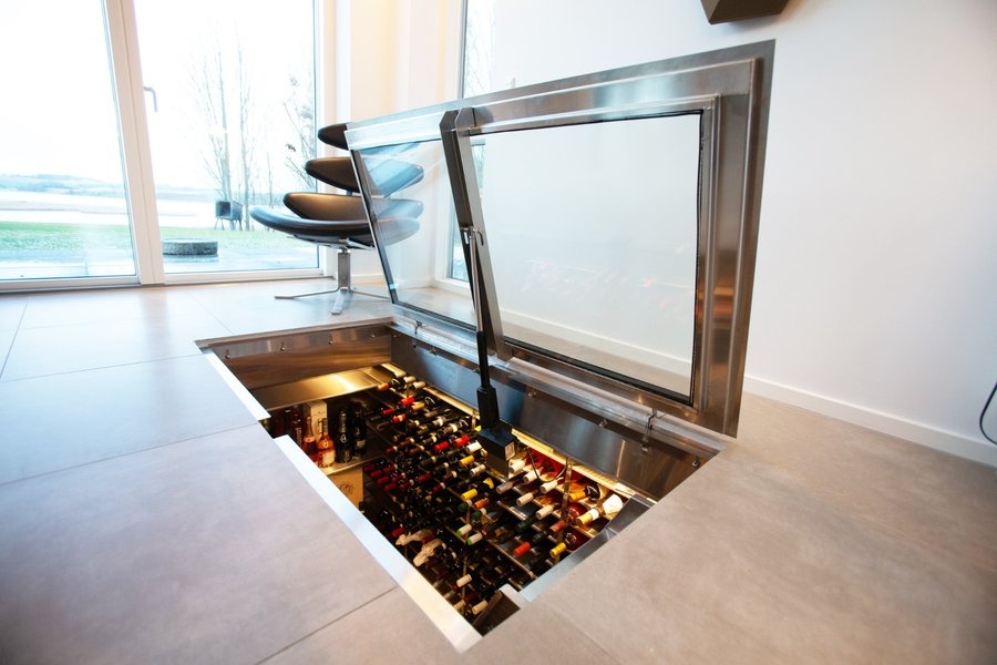 Vinkjeller på spesialmål i gulvet med elegant glassluke og vinflasker
